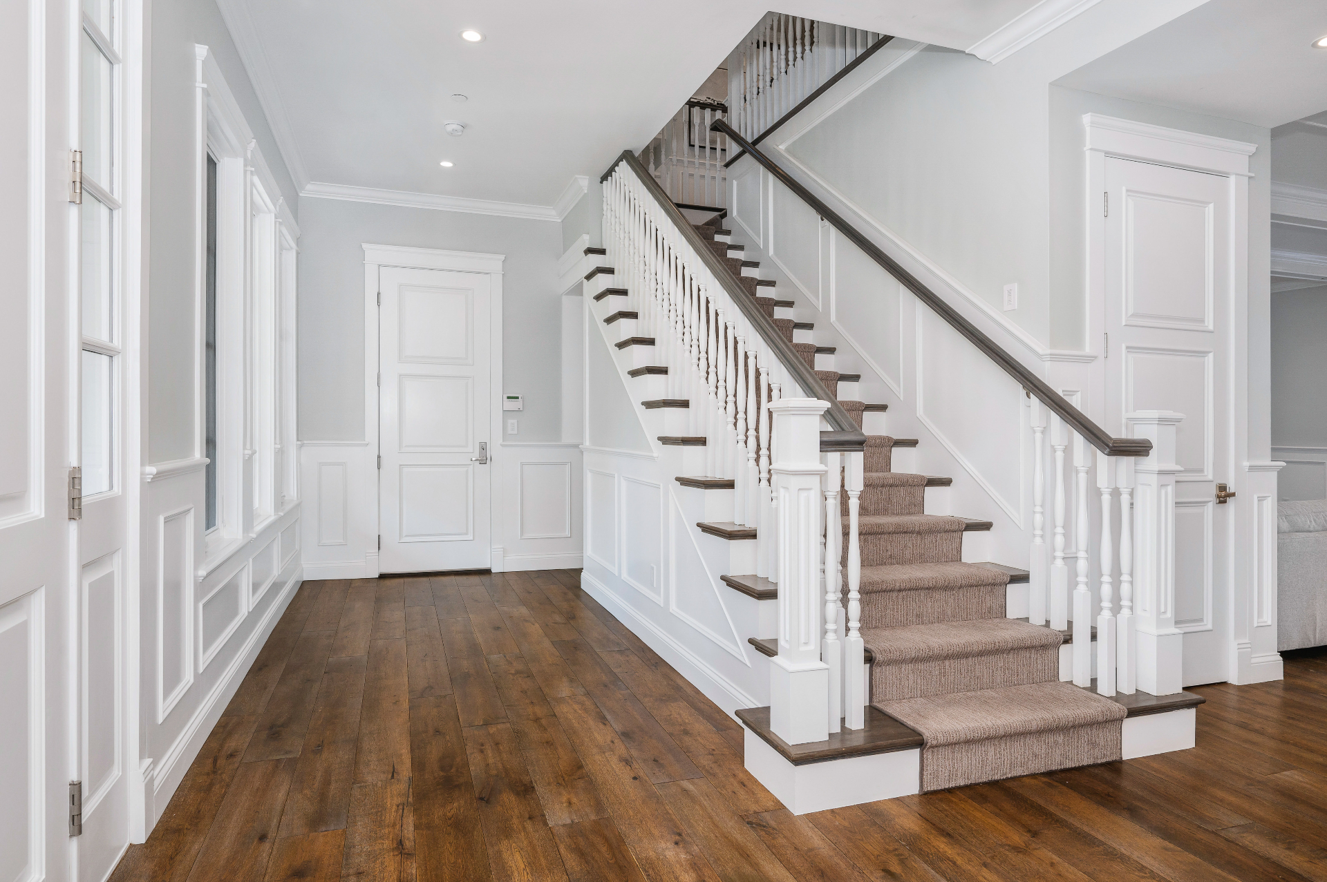 Traditional white turned baluster staircase with wood treads